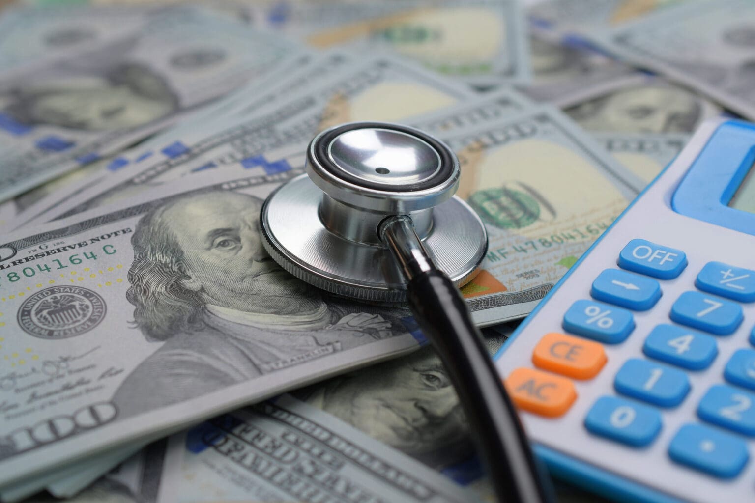 Stethoscope, money, and calculator collage representing healthcare costs