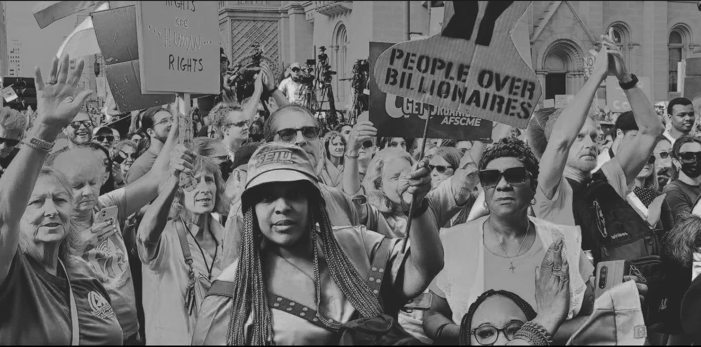 Protesters holding signs 'people over billionaires'
